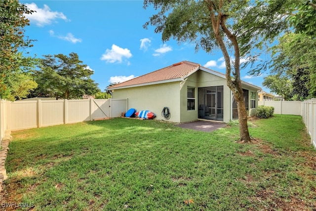 back of house with a yard and a sunroom