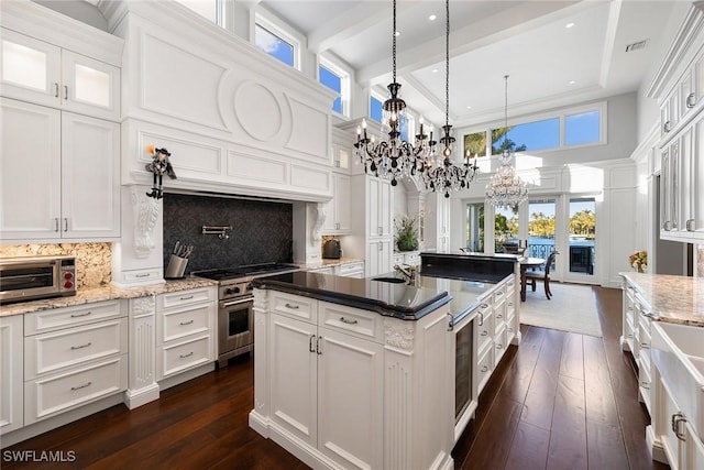 kitchen featuring a toaster, stainless steel range, visible vents, an inviting chandelier, and white cabinetry