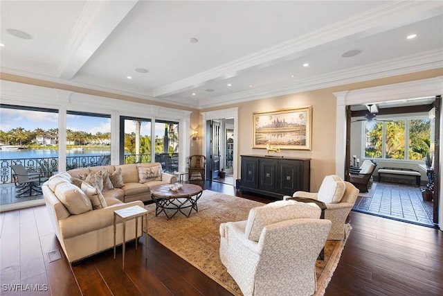 living room with recessed lighting, a water view, beam ceiling, dark wood finished floors, and crown molding