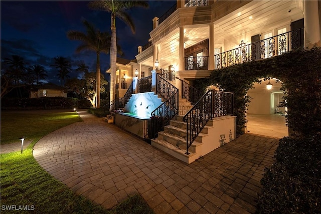 exterior space featuring an outdoor hot tub and stairs