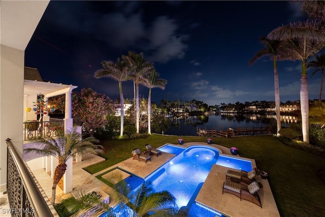 pool at twilight with an outdoor pool, a patio area, a yard, and a water view