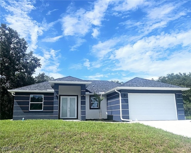 view of front of property featuring a front lawn and a garage