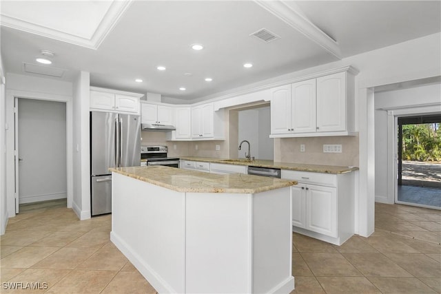 kitchen featuring appliances with stainless steel finishes, sink, white cabinets, a center island, and light tile patterned flooring