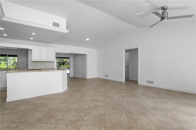 unfurnished living room with ceiling fan, light tile patterned flooring, lofted ceiling, and a wealth of natural light