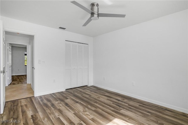 unfurnished bedroom featuring a closet, ceiling fan, and dark wood-type flooring