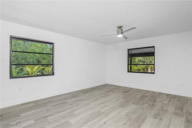 empty room featuring ceiling fan, a healthy amount of sunlight, and light hardwood / wood-style floors