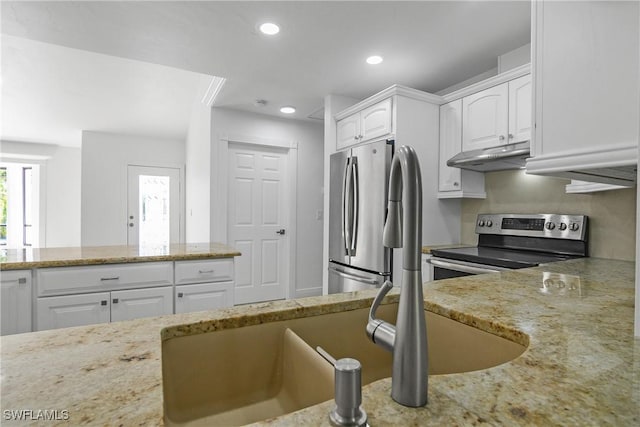 kitchen with light stone countertops, white cabinetry, and stainless steel appliances