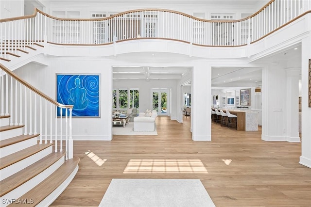 entrance foyer featuring a high ceiling, beam ceiling, crown molding, and hardwood / wood-style floors