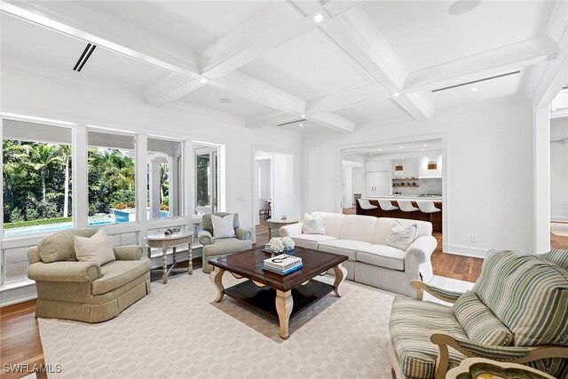 living room with beamed ceiling, coffered ceiling, and light hardwood / wood-style flooring