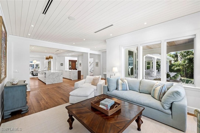 living room featuring hardwood / wood-style floors, wooden ceiling, and sink