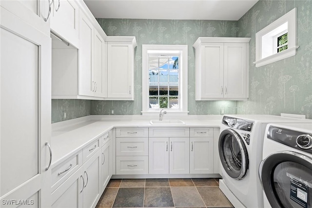 washroom featuring washing machine and clothes dryer, a wealth of natural light, cabinets, and sink