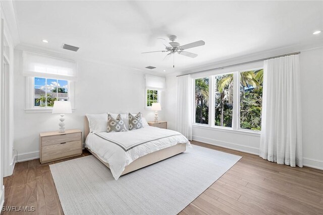 bedroom featuring ceiling fan, hardwood / wood-style floors, and crown molding