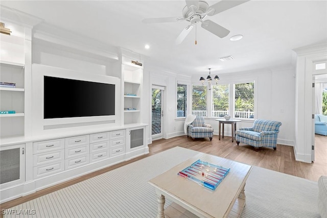 living room featuring built in features, light hardwood / wood-style floors, and ceiling fan with notable chandelier