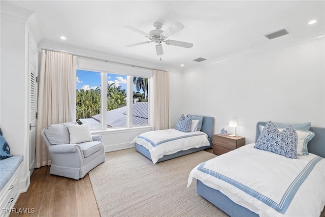 bedroom with hardwood / wood-style floors, ceiling fan, and crown molding