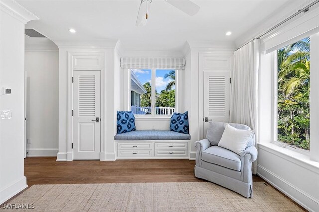 sitting room with ceiling fan, light hardwood / wood-style floors, and ornamental molding