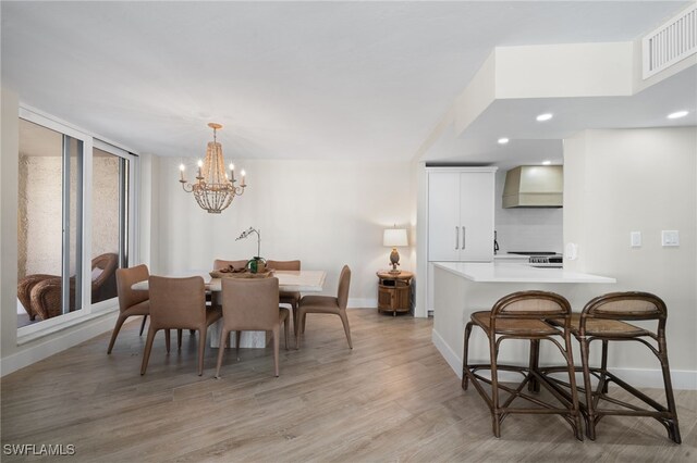 dining room with hardwood / wood-style floors and an inviting chandelier