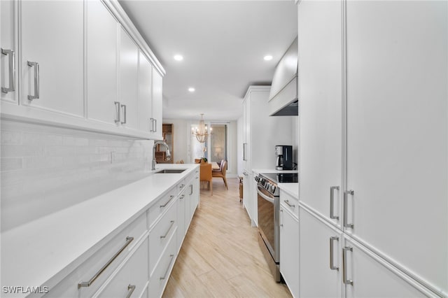 kitchen with pendant lighting, custom exhaust hood, electric stove, light hardwood / wood-style flooring, and white cabinetry