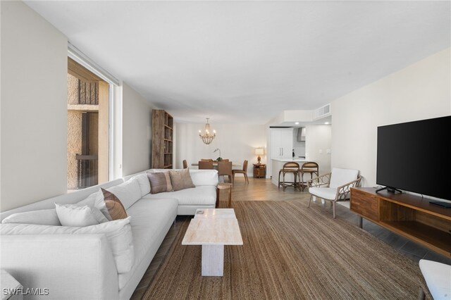 living room with a chandelier and dark hardwood / wood-style floors