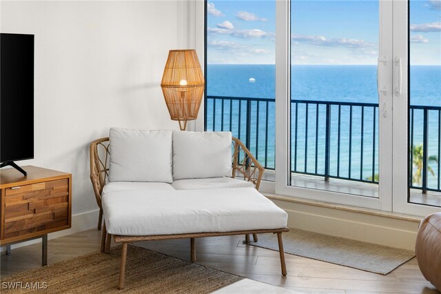 living area with hardwood / wood-style flooring and a water view