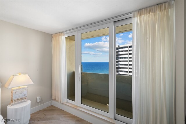 doorway to outside featuring a water view and light hardwood / wood-style floors