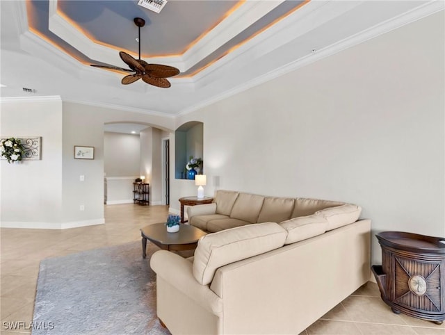 tiled living room with ceiling fan, crown molding, and a tray ceiling