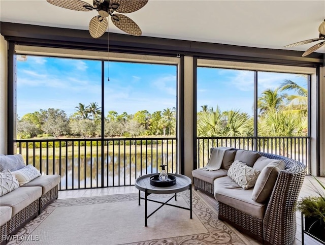 sunroom / solarium featuring a water view, plenty of natural light, and ceiling fan