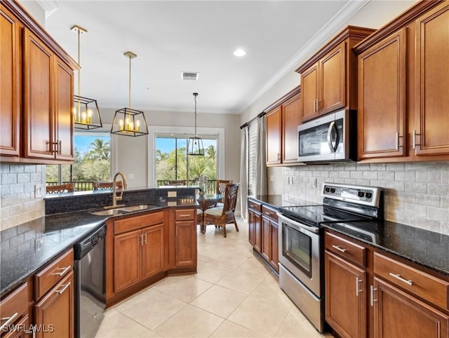 kitchen featuring sink, dark stone counters, decorative light fixtures, appliances with stainless steel finishes, and ornamental molding