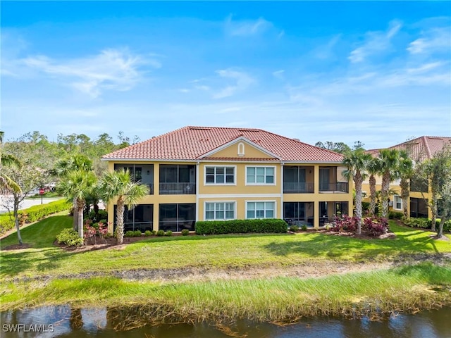 back of property with a yard and a water view