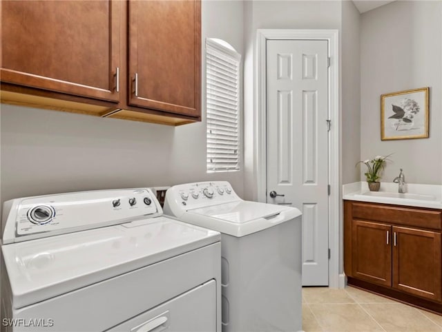 washroom with cabinets, light tile patterned floors, sink, and washing machine and clothes dryer