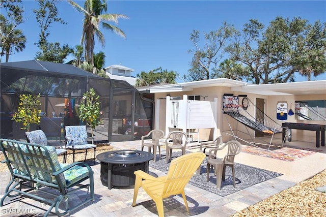 view of patio with a lanai and a fire pit