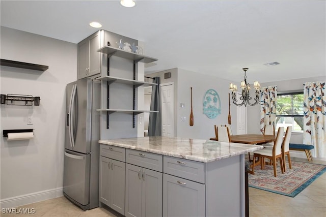 kitchen featuring stainless steel fridge, gray cabinets, and open shelves