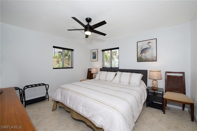 bedroom featuring ceiling fan, light tile patterned floors, and multiple windows