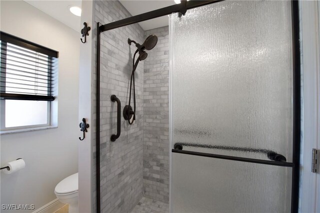 bathroom featuring an enclosed shower and toilet