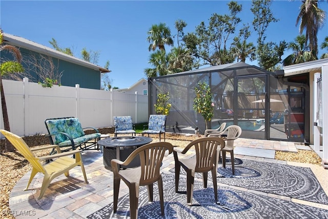 view of patio / terrace with an outdoor fire pit, a lanai, a fenced in pool, and fence