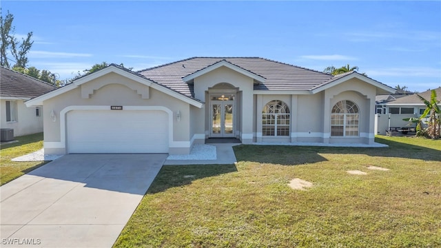 single story home featuring french doors, cooling unit, a front yard, and a garage