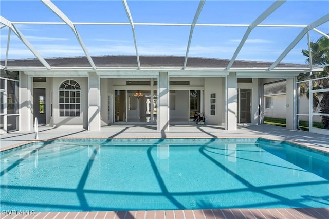 view of pool with glass enclosure and a patio area