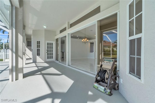 sunroom with a healthy amount of sunlight and a notable chandelier