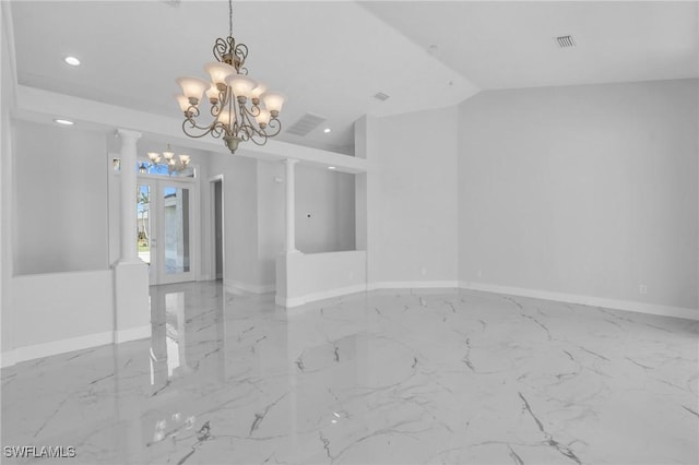 spare room with french doors, vaulted ceiling, decorative columns, and an inviting chandelier