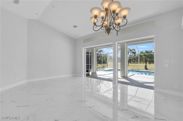 spare room featuring a chandelier and lofted ceiling