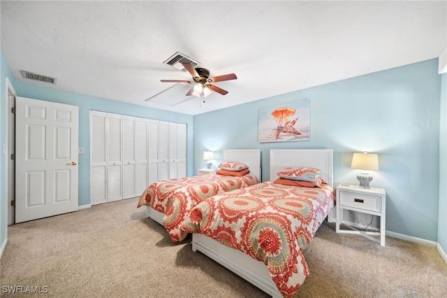 carpeted bedroom featuring a closet and ceiling fan