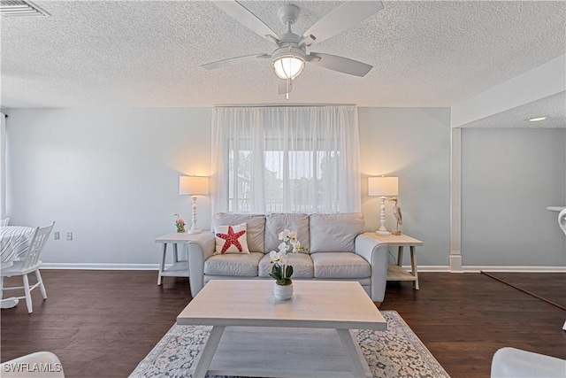 living room with a textured ceiling, dark hardwood / wood-style floors, and ceiling fan