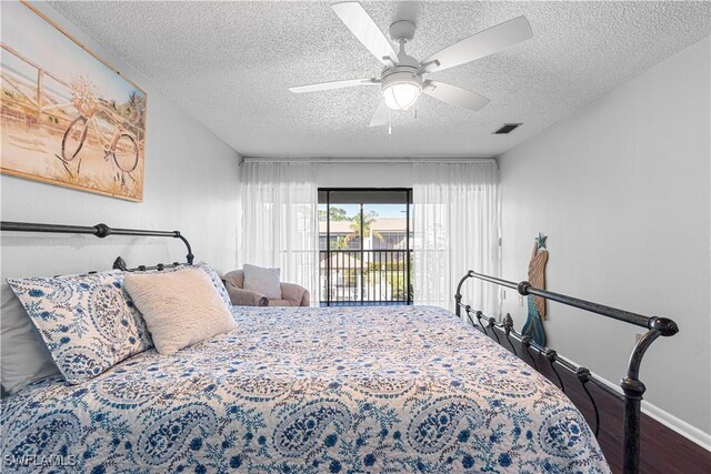 bedroom featuring ceiling fan, access to exterior, wood-type flooring, and a textured ceiling