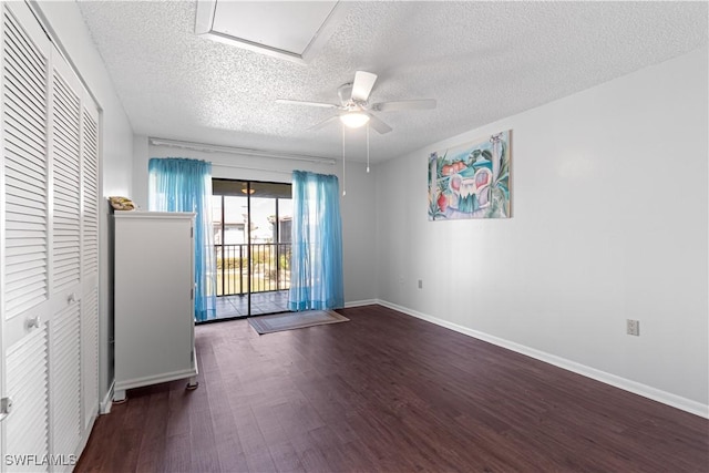 unfurnished room with ceiling fan, a textured ceiling, and dark wood-type flooring