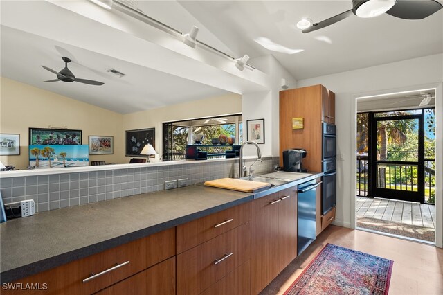 kitchen with ceiling fan, sink, tasteful backsplash, double oven, and lofted ceiling