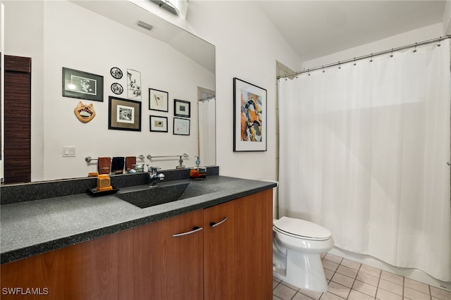 bathroom with tile patterned flooring, vanity, toilet, and lofted ceiling