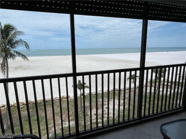 exterior space with a view of the beach, a water view, and a wealth of natural light