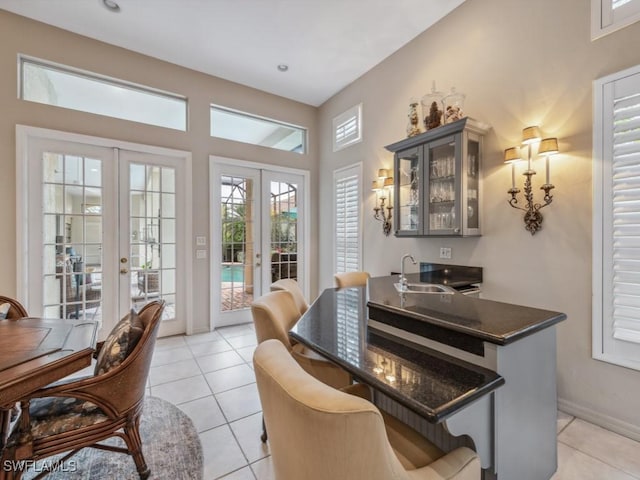 dining area with french doors, wet bar, and light tile patterned floors