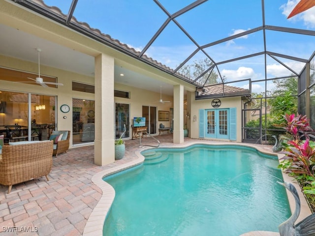 view of swimming pool with french doors, ceiling fan, glass enclosure, and a patio area