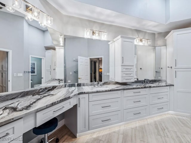 bathroom with vanity, a towering ceiling, and toilet