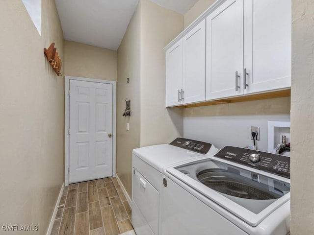 washroom featuring cabinets and washer and clothes dryer